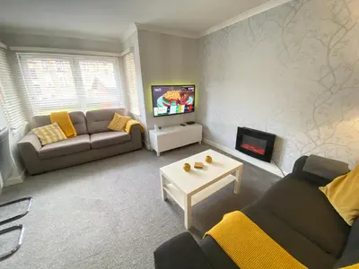 a living room with a couch and a tv at Paisley Central Apartment #2 in Paisley