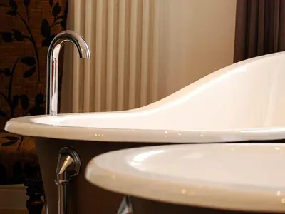 a bathroom with a white sink with a faucet at Monachyle Mhor Hotel in Lochearnhead