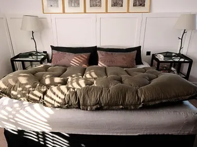 a large bed in a bedroom with two tables at Monachyle Mhor Hotel in Lochearnhead