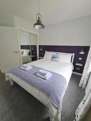 a bedroom with a large bed with towels on it at The Clamshell, Oban in Oban