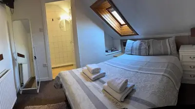 a bedroom with a bed with towels on it at Arbour Guest House in Oban