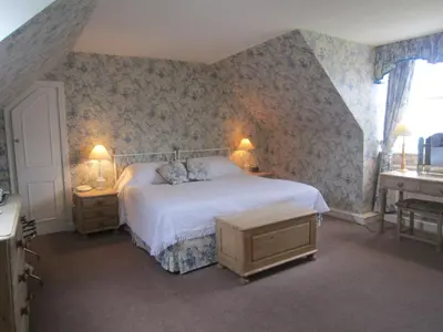 a bedroom with a bed and two tables and a window at The Creggans Inn in Strachur