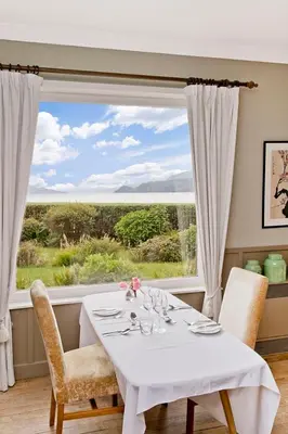 a dining room with a table and a large window at The Creggans Inn in Strachur