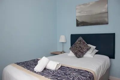 a bedroom with a bed with towels on it at Craignelder Hotel in Stranraer