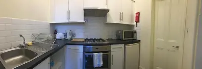 a kitchen with a sink and a stove top oven at Menzies Apartments in Edinburgh
