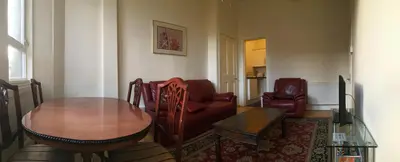 a living room with a table and a couch and chairs at Menzies Apartments in Edinburgh