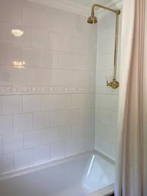a white bathroom with a tub and a shower curtain at The Lagg in Lagg
