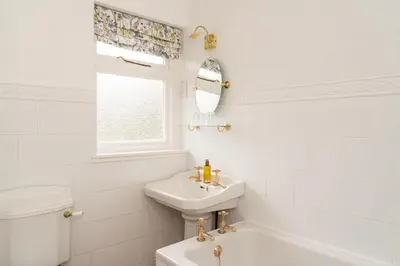 a white bathroom with a sink and a toilet at The Lagg in Lagg