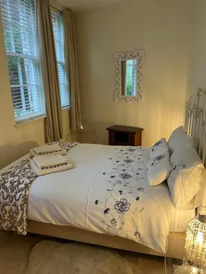 a bedroom with a white bed with blue and white sheets at The cosy courtyard in Edinburgh