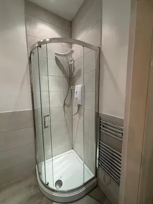 a shower with a glass enclosure in a bathroom at The cosy courtyard in Edinburgh
