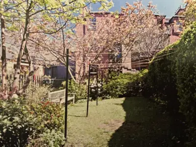 a garden with a bench and trees and buildings at The cosy courtyard in Edinburgh
