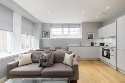 a living room with a couch and a kitchen at Destiny Scotland Apartments at Canning Street Lane in Edinburgh