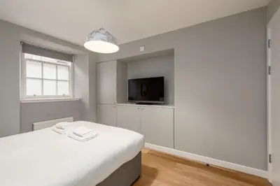 a bedroom with a bed and a flat screen tv at Destiny Scotland Apartments at Canning Street Lane in Edinburgh