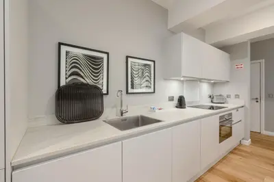 a kitchen with white cabinets and a sink at Destiny Scotland Apartments at Canning Street Lane in Edinburgh