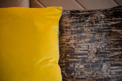 a yellow pillow sitting next to a brick wall at Lochside House Hotel & Spa in New Cumnock