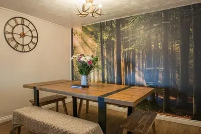 a dining room table with a vase of flowers on it at Country Nest in Carnwath