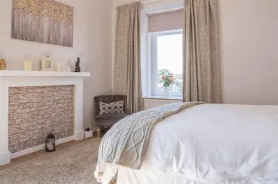 a bedroom with a bed and a fireplace at Country Nest in Carnwath