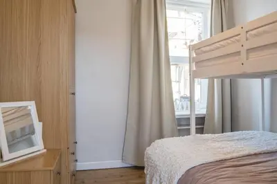 a bedroom with a bed and a mirror and a window at Country Nest in Carnwath