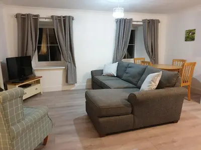a living room with a couch and a chair at The Old School in Salen