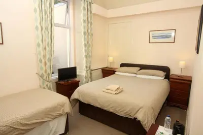 a bedroom with two beds and a window at Dean Park Guest House in Kilmarnock