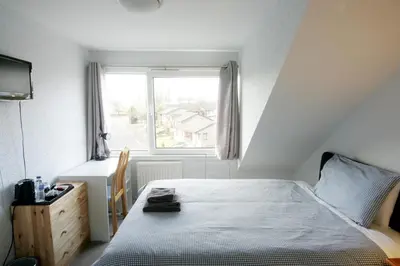 a bedroom with a bed and a window at Dean Park Guest House in Kilmarnock