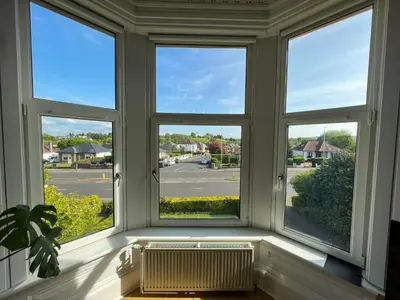 a window with three views of a street at A Spacious Flat with Character - Private Car Space in Paisley