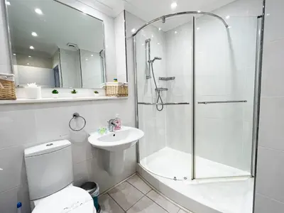 a bathroom with a shower and a toilet and a sink at A Spacious Flat with Character - Private Car Space in Paisley
