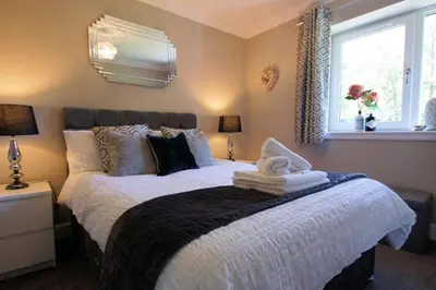 a bedroom with a bed with towels on it at Riverbank in Callander