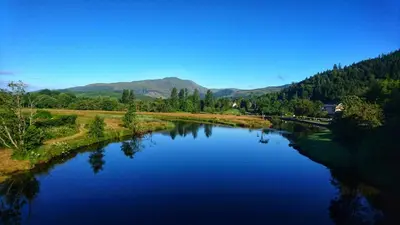 a view of a river with mountains in the background at Riverbank in Callander