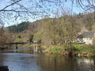 a river with a bridge in the middle of it at Riverbank in Callander