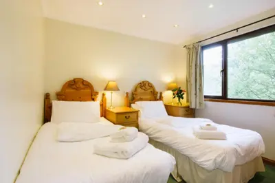 two beds in a room with towels on them at The Buzzard Lodge 2 bedroom sleeps up to 4 in Crianlarich
