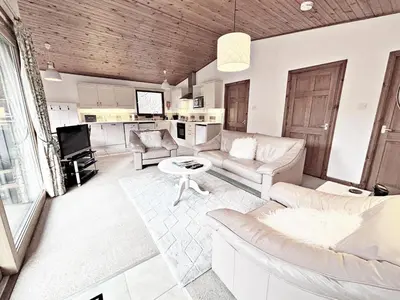 a living room with a couch and a table at Fisher Lodge sleeps up to 2 in Crianlarich