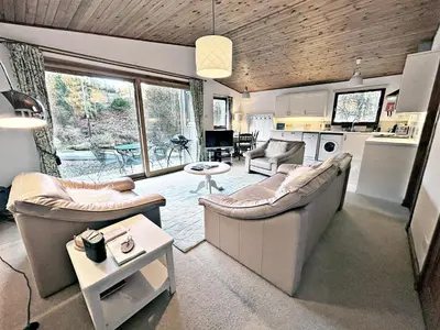 a living room with two couches and a kitchen at Fisher Lodge sleeps up to 2 in Crianlarich