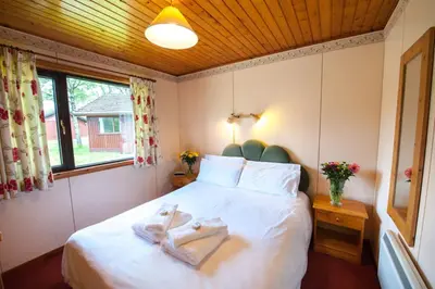 a bedroom with a bed with two towels on it at Heron Lodge sleeps up to 4 with free wifi in Crianlarich
