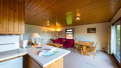 a kitchen and living room with a couch and a table at 2 bedroom lodge with stunning loch mountain views in Crianlarich