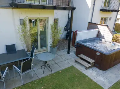 a backyard with a hot tub and a table and chairs at Mains of Taymouth Country Estate 4* Houses in Kenmore