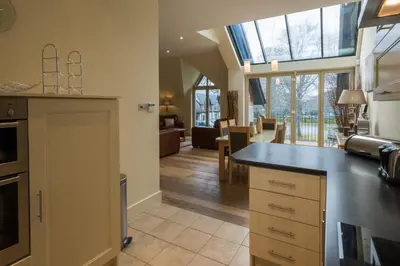 a kitchen with a counter and a living room at Mains of Taymouth Country Estate 4* Houses in Kenmore