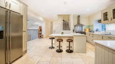a kitchen with a counter and stools in it at Mains of Taymouth Country Estate 5* Houses in Kenmore