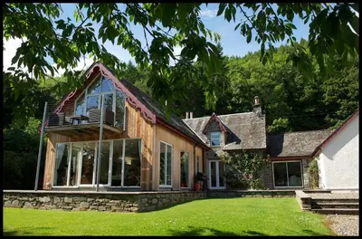 a house with large windows and green grass at Mains of Taymouth Country Estate 5* Houses in Kenmore