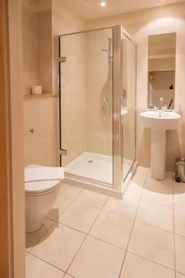 a bathroom with a shower and a toilet and a sink at Mains of Taymouth Country Estate 5* Houses in Kenmore