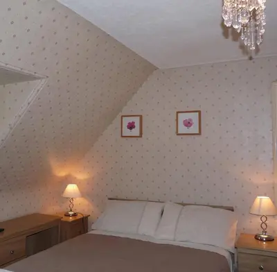 a bedroom with a bed with two night stands and two lamps at St Annes Guest House in Oban