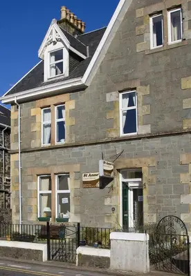 a stone building with a sign in front of it at St Annes Guest House in Oban