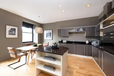 a kitchen with a table and a dining room at JOIVY Luxury Home on George Street in Edinburgh