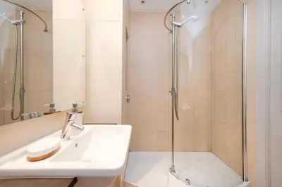 a white bathroom with a shower and a sink at JOIVY Luxury Home on George Street in Edinburgh
