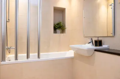 a bathroom with a sink and a shower at JOIVY Luxury Home on George Street in Edinburgh