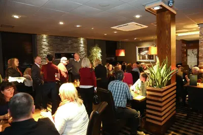 a crowd of people standing in a restaurant at Mondo Hotel in Coatbridge
