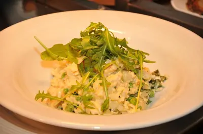 a white plate of food with greens on top at Mondo Hotel in Coatbridge
