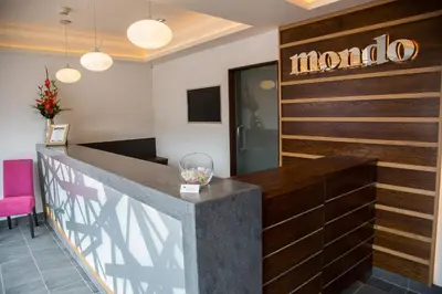 a lobby with a bar with a neon sign on the wall at Mondo Hotel in Coatbridge