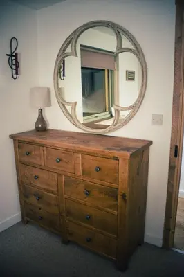 a dresser with a mirror on top of it at Cosy Cottage in Glencoe