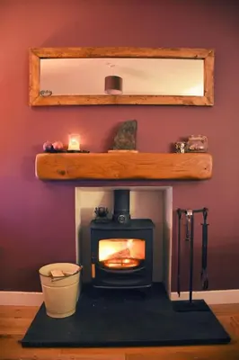 a wood stove in a room with a wall at Cosy Cottage in Glencoe